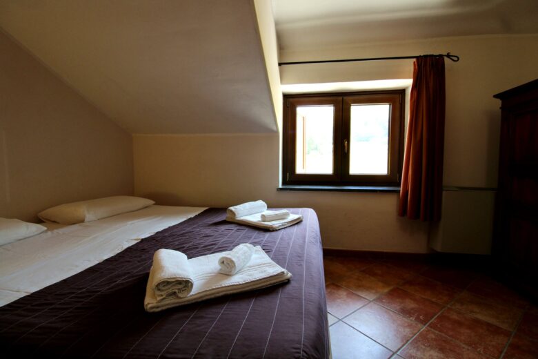 Letto matrimoniale e finestra della Camera 104 Acqua Spasa