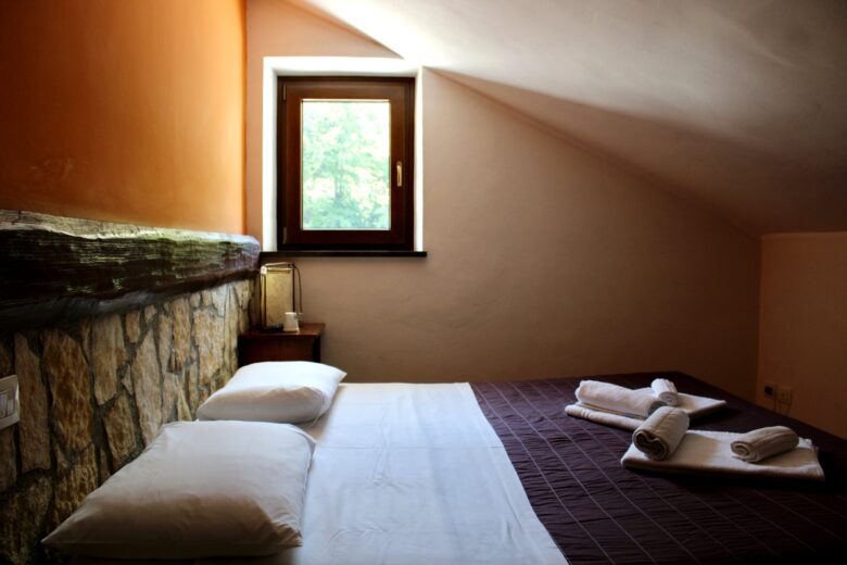 Letto matrimoniale e finestra della Camera 112 Antro dei Tassi